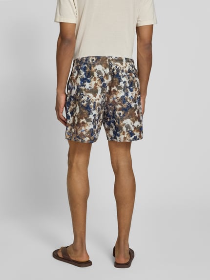 Männermodel trägt Shorts im Allover-Look mit elastischem Bund von ARMANI EXCHANGE, gemusterte Farben, Regular Fit, Ganzkörperansicht Rückansicht.