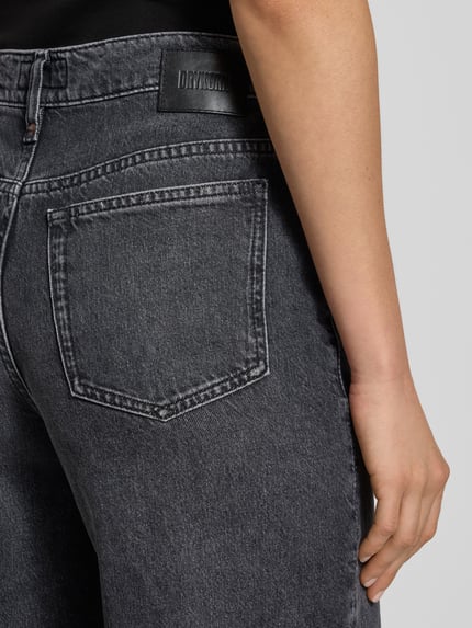 Frauenmodel trägt Wide Leg Jeans Modell 'FLUNG' von Drykorn aus Baumwoll-Lyocell-Mix, dunkles Grau mit Eingrifftaschen, Detailaufnahme Rückansicht.