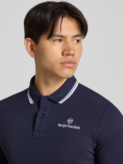 Männermodel trägt Slim Fit Poloshirt mit Logo-Stitching Modell 'Reed' von SERGIO TACCHINI in Dunkelblau, Nahaufnahme Oberkörper. Elastischer Baumwoll-Mix, kurzärmlig, Polokragen, Logo auf Brust.