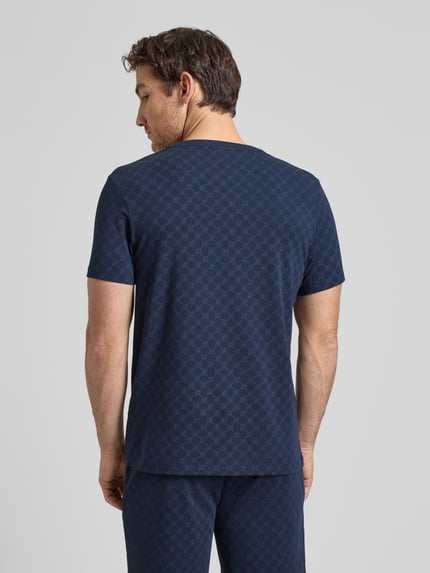Männermodel trägt T-Shirt mit Logo-Muster und Rundhalsausschnitt von JOOP! Collection, Baumwoll-Elasthan-Mix, Regular-Fit, Rückenlänge 68 cm, Ganzkörperansicht Rückansicht.