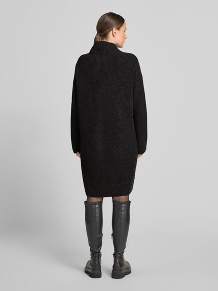 Frauenmodel trägt Loose Fit Strickkleid aus Woll-Mix von Marc O'Polo in Dunkelgrau mit grober Strickstruktur, Ganzkörperansicht Rückansicht. Damen Strickkleid von Marc O'Polo.