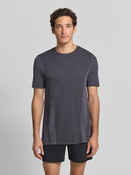 Männermodel trägt Regular Fit Sport-T-Shirt mit Logo-Print von Under Armour in Dunkelgrau, feine Struktur, Ganzkörperansicht von vorne. Herren Sport-T-Shirt von Under Armour