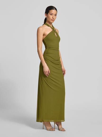 Vrouwenmodel draagt maxi-jurk met halter model 'Jayni Halter Hardware' van Forever New in olijfgroen met cut-out en drapering, nauw aansluitend model, ruglengte maat 36: 20 cm, borstwijdte maat 36: 35 cm. Ganzkörperansicht von voren.