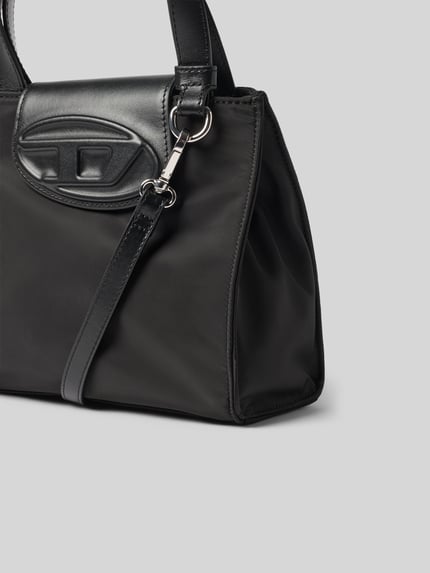 Produktfoto, Tasche mit Rindsleder-Anteil von Diesel in Schwarz, abnehmbarer Schulterriemen, Logo-Detail, glatte und matte Texturen, Kontext: Damen Tasche von Diesel, Hauptfach mit Überschlag, Breite 22 cm, Länge 19 cm, Tiefe 10 cm