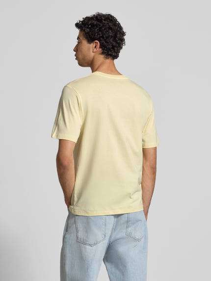 Męski model nosi T-Shirt mit Statement-Print Modell 'RHYERES' od Jack & Jones, bawełna woskowana, krój regular fit, widok całej sylwetki z tyłu.