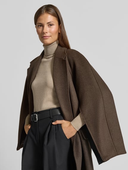 Frauenmodel trägt Relaxed Fit Mantel mit Woll-Anteil Modell 'Malini' von HUGO in Braun, kombiniert mit schwarzer Hose, Nahaufnahme Oberkörper, Damen Mantel von HUGO.