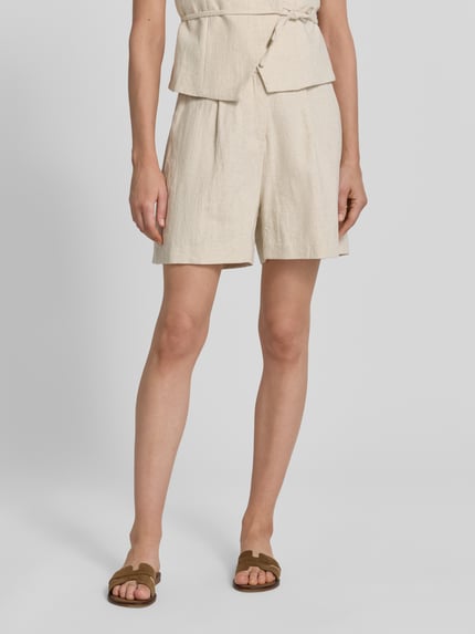 Frauenmodel trägt Shorts aus Ramie-Mix mit Biesen Modell 'Sega' von Neo Noir, Ramie-Baumwoll-Mix in Natur, Straight Fit, Nahaufnahme Unterkörper.