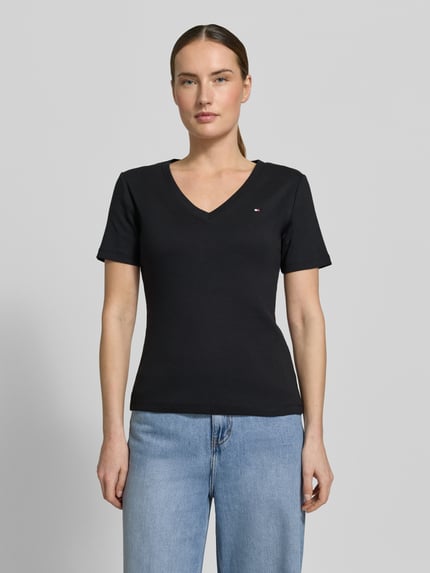 Vrouwenmodel draagt Slim Fit T-shirt uit zuiver katoen van Tommy Hilfiger, look: effen kleuren, pasvorm: slim fit, V-hals, korte mouw, jersey, applicatie met gestikt logo, ganzebodyaanzicht van voren.