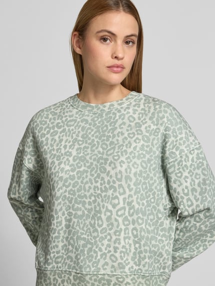 Kobiece model prezentuje Sweatshirt mit Rundhalsausschnitt od Lala Berlin z bawełny, krój regular fit, animal print, elastyczne wykończenia, długość tyłu 55 cm w rozm. S, pastelowe odcienie i tekstura dzianiny, zbliżenie na górną część ciała