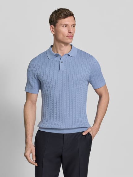 Męski model nosi Slim Fit Poloshirt in Strick-Optik od Christian Berg Men, jasnoniebieski, krótki rękaw, krój slim fit, czysta bawełna, widok całej sylwetki z przodu.