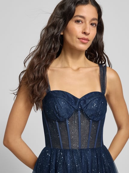 Frauenmodel trägt Schimmerndes Abendkleid in semitransparenter Optik von Hey Kyla aus Tüll, taillierter Schnitt, Corsagenkleid, Nahaufnahme Oberkörper.