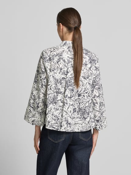 Vrouwenmodel draagt Regular Fit Langarmbluse aus Lyocell im Allover-Look van Windsor, wit met grijs bladmotief, rugaanzicht, context: dames langarmblouse, puur lyocell, regular fit, allover-print, overhemdkraag, volledige knopenlijst, lange mouwen, ruglengte maat 36: 60 cm, borstwijdte: 47 cm, mouwlengte: 52 cm.