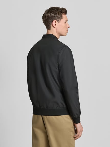 Männermodel trägt schwarze Jacke mit Stehkragen Modell 'clay' von Matinique, Regular-Fit, Rückenansicht, glatte Textur, Rückenlänge 67 cm.