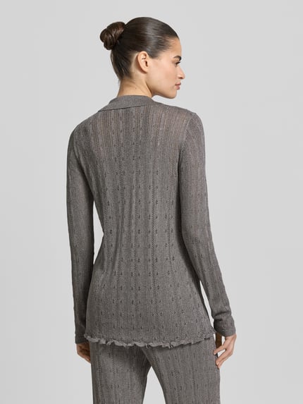 Frauenmodel trägt Strickshirt mit Polokragen und durchgehender Knopfleiste von Jake*s Collection, Material-Mix mit Viskose-Anteil, Slim Fit, in Grau mit feinem Lochmuster, Ganzkörperansicht Rückansicht.