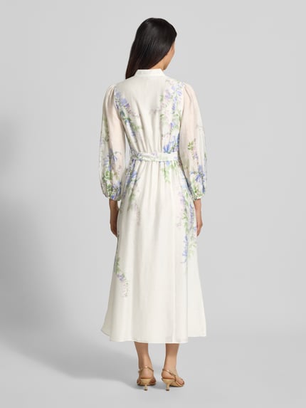 Frauenmodel trägt Abendkleid aus Lyocell-Leinen-Mix Modell 'Sheridan' von Forever New in Creme mit Blumenmuster, fließende Stoffstruktur, taillierte Passform, Stehkragen, 3/4-Arm, Rückansicht ganzkörper