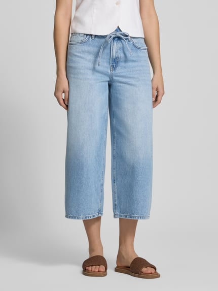 Vrouwenmodel draagt Regular Fit Culotte uit zuivere katoen model 'GIANNA' van Only in effen lichtblauw denim met 5-pocketdesign, ceintuurlussen, knoop- en ritssluiting, mid waist, zichtbaar materiaaltextuur; close-up van het onderlichaam.