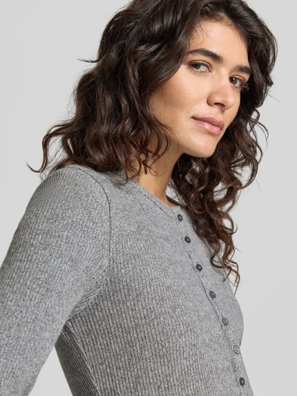 Frauenmodel trägt Langarmshirt Modell 'Saltus' mit Zierknöpfen von OPUS in grauer Melange-Strickoptik, Regular Fit, Nahaufnahme Oberkörper.