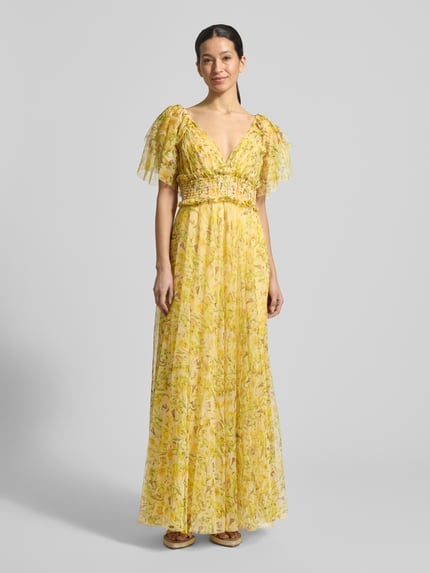 Frauenmodel trägt Abendkleid aus Tüll mit V-Ausschnitt von LACE & BEADS in Gelb, florales Muster, taillierter Maxikleid-Schnitt, Ganzkörperansicht von vorne.