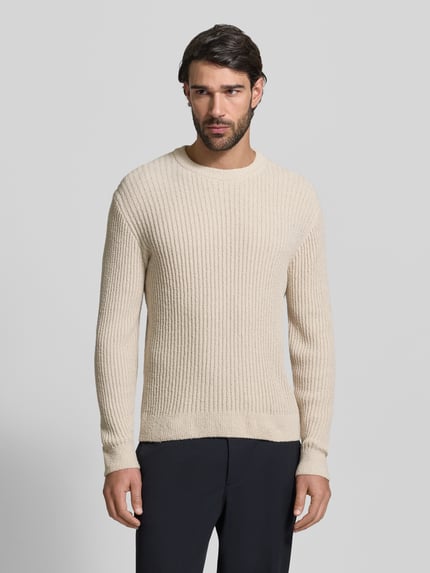 Męski model nosi Slim Fit Pullover in Strick-Optik von JAKE*S STUDIO MEN, mieszanka bawełny, krój slim fit, okrągły dekolt, długość tyłu w rozmiarze M 65 cm, długość rękawów 64 cm, jasny beż, imitacja dzianiny, cała sylwetka z przodu.