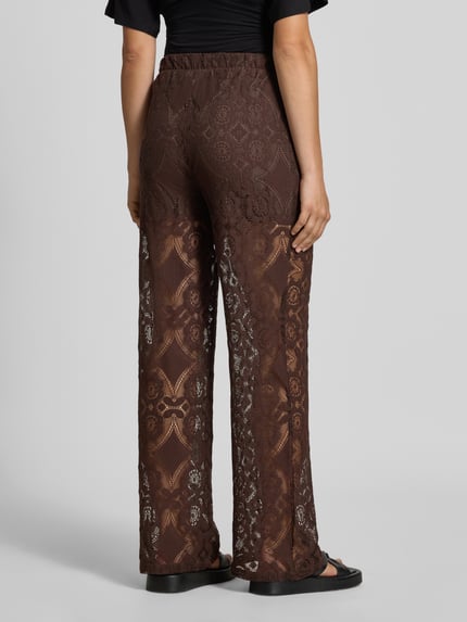 Vrouwenmodel draagt Stoffen broek van Kant Model 'ALMI' van YAS, Materiaalmix met katoen, regular fit, elastische band, ondoorzichtige ondershorts, bandwijdte maat 36: 35 cm, binnenbeenlengte maat 36: 75 cm, volledig bruin met kantmotief, volledige rugaanzicht.