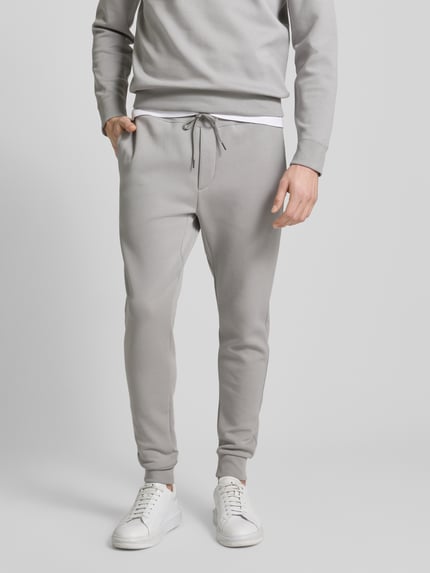 Männermodel trägt Sweatpants mit elastischem Bund von Polo Ralph Lauren aus Baumwoll-Mix, lockerer Schnitt, Tunnelzug, Eingrifftaschen, Gesäßtasche, Innenbeinlänge 76 cm bei Größe M, Ganzkörperansicht von vorne.