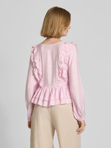 Frauenmodel trägt Regular Fit Langarmbluse aus Viskose-Mix Modell 'ZOEY' von Vero Moda in Hellrosa mit Flounce-Detail, Ganzkörperansicht Rückansicht.