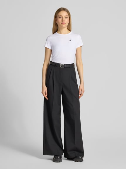 Kobiece modelka nosi Regular Fit T-Shirt aus reiner Baumwolle Modell 'Eventsa11' od BOSS, biała gładka koszulka z krótkim rękawem, okrągły dekolt, detal z logo, jerseyowa struktura, widok całej sylwetki z przodu