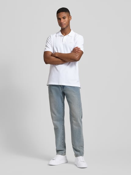 Männermodel trägt weißes Slim Fit Poloshirt mit Label-Stitching von GAP aus Baumwoll-Elasthan-Mix, Ganzkörperansicht von vorne
