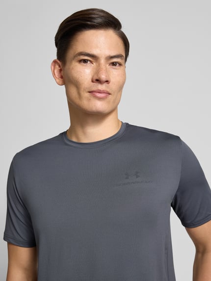 Männermodel trägt T-Shirt mit Logo Modell 'Vanish Energy' van Under Armour, grijs, regular fit, stretch materiaal, logo op borst, Nahaufnahme Oberkörper.