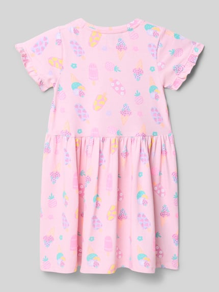 Meisje draagt Regular Fit Shirtkleid met all-over motiefprint van DANAMADE, roze katoenmix met ruches, ruglengte maat 116, Ganzkörperansicht Rückansicht.