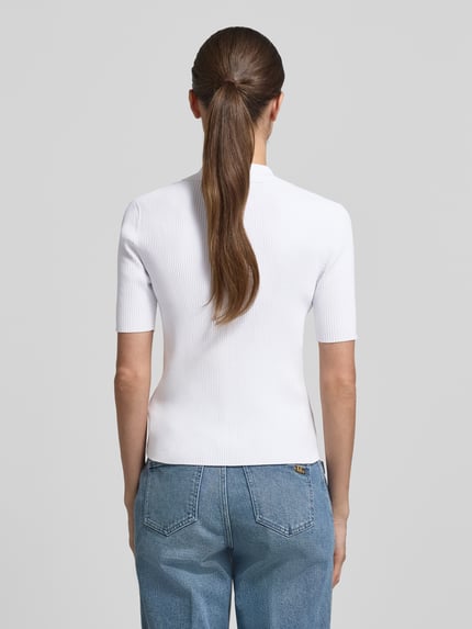 Vrouwenmodel draagt 'Strickshirt mit Schnürung und Umlegekragen' van MICHAEL Michael Kors, wit, viscosemix met stretch, nauwsluitend model, fijnrib, labeldetails, platte kraag, rugaanzicht, detailopname.