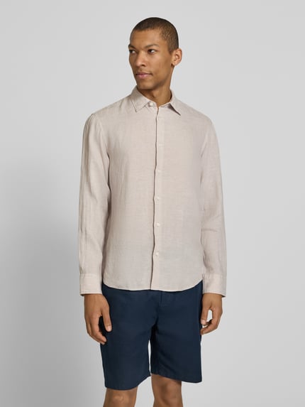Männermodel trägt Regular Fit Freizeithemd aus reinem Leinen Modell 'REGKYLIAN' von SELECTED HOMME in Beige mit Kentkragen, Ganzkörperansicht von vorne.