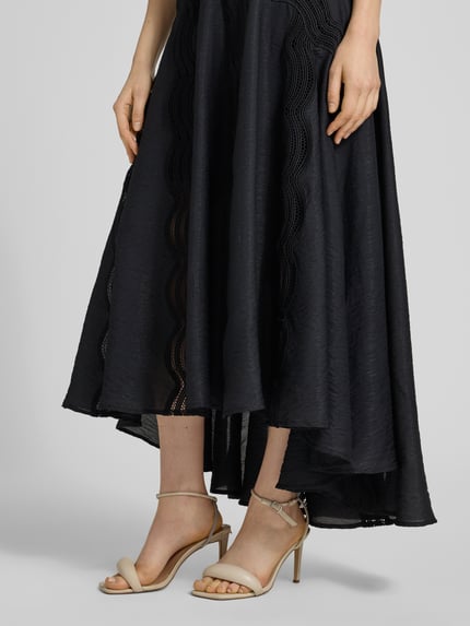 Kobiece modelka nosi Midirock mit Stitchings Modell 'COLE' od Copenhagen Muse, czarny, lekka faktura, detaliczne przeszycia, mikromodal z domieszką stretchu, fason A-linia, szerokość w rozmiarze S: 36 cm, długość całkowita S: 86 cm, zbliżenie na dolną część sylwetki