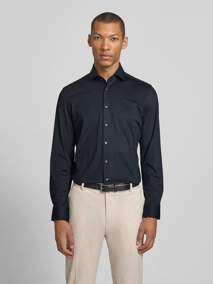 Männermodel trägt Slim Fit Business-Hemd mit Haifischkragen von SEIDENSTICKER, dunkelblau, glatte Struktur, Material-Mix mit Stretch-Anteil, Knopfleiste, Ganzkörperansicht von vorne. Rückenlänge 76 cm, Schulterbreite 43 cm, Ärmellänge 63 cm bei Größe 40.
