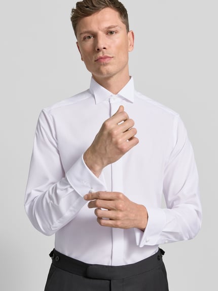 Männermodel trägt Modern Fit Business-Hemd mit verdeckter Knopfleiste von OLYMP aus reiner Baumwolle Kentkragen Nahaufnahme Oberkörper.