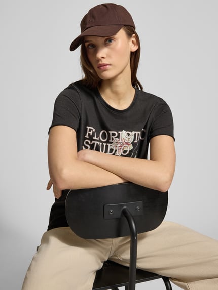 Vrouwenmodel draagt Regular Fit T-Shirt uit pure katoen model 'LUCY' van Only, effen, motiefprint, ronde hals, korte mouw, jersey, detailopname bovenlichaam.