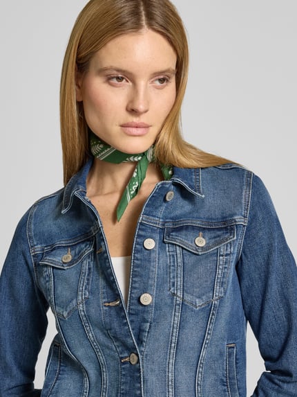 Frauenmodel trägt Jeansjacke mit Umlegekragen von Christian Berg Woman aus Baumwoll-Mix mit Stretch-Anteil in blauer Denim-Optik, taillierter Schnitt, Knopfleiste, geknöpfte Brusttaschen und seitliche Eingrifftaschen, Nahaufnahme Oberkörper.