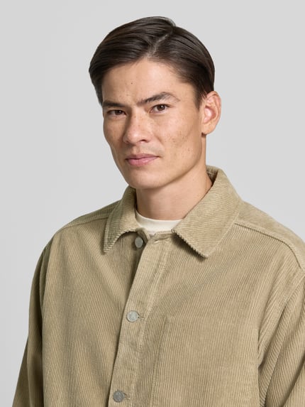 Männermodel trägt Relaxed Fit Freizeithemd aus reiner Baumwolle von ARMEDANGELS in Beige mit Hemdkragen, Nahaufnahme Oberkörper, Herren Freizeithemd