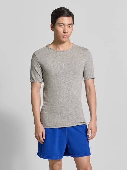Männermodel trägt Slim Fit T-Shirt mit Rundhalsausschnitt Modell 'Sonoma' von American Vintage in Grau, reine Baumwolle, Ganzkörperansicht von vorne.