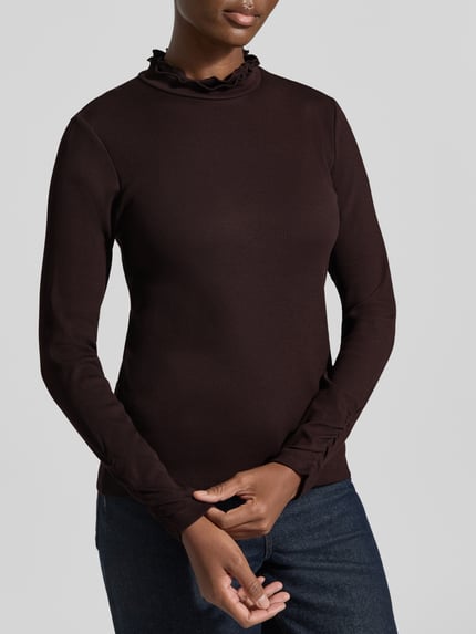 Frauenmodel trägt Slim Fit Longsleeve aus Baumwoll-Mix von MORE & MORE in Dunkelbraun mit Strukturmuster und Stehkragen, Nahaufnahme Oberkörper. Damen Longsleeve aus elastischem Baumwoll-Mix, Rückenlänge bei Größe 36: 58 cm.
