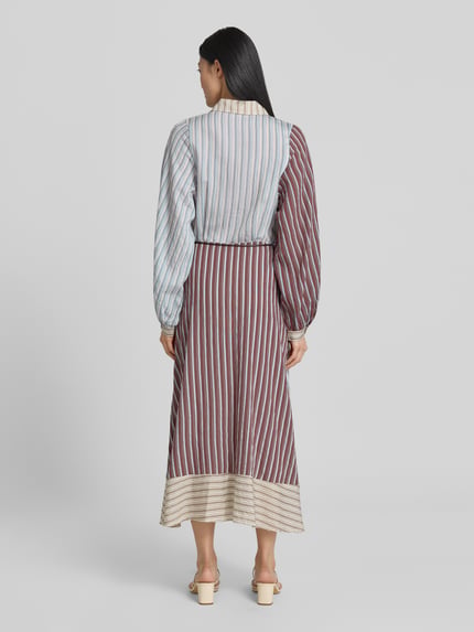 Kobiece modelka nosi sukienkę koszulową 'Hemdblusenkleid aus Lyocell-Mix mit Bindegürtel' od Jake*s Casual, mieszanka lyocellu z dodatkiem wiskozy, linia a, sukienka midi, wzór na całej powierzchni, zakryta listwa guzikowa, wiązany pasek, długość tyłu w rozmiarze 36: 124 cm, szerokość w rozmiarze 36: 41 cm, długość rękawów w rozmiarze 36: 57 cm, kolory: błękit, brąz, beż, tkanina z wyraźną strukturą, widoczny kontrast pasów, całkowity widok od tyłu.