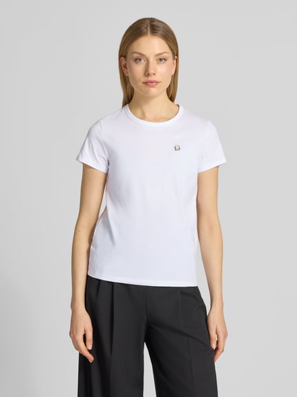 Modelka nosi Regular Fit T-Shirt aus reiner Baumwolle Modell 'Eventsa11' od BOSS, biały kolor, okrągły dekolt, krótki rękaw, jersey, detal z logo, unikalna faktura bawełny, przód w całości, zdjęcie całopostaciowe z przodu.
