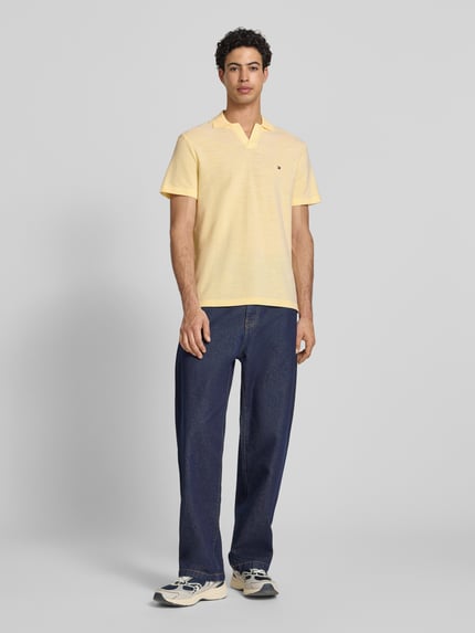 Männermodel trägt Regular Fit poloshirt uit puur katoen van Tommy Hilfiger, melangelook, gestikt logo, polokraag, V-hals, korte mouw, Ganzkörperansicht van voren.