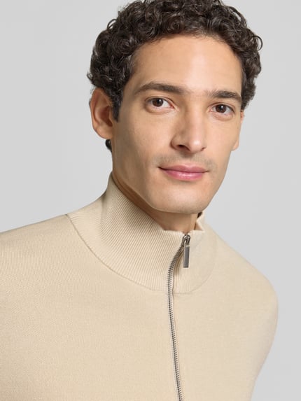 Männermodel trägt Strickjacke mit Zweiwege Reißverschluss von Selected Homme, beige, strukturierte Feinstrick-Optik, Nahaufnahme Oberkörper.