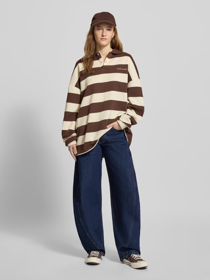 Vrouwenmodel draagt Loose Fit Jeans uit katoenmix van Tommy Jeans in denimlook, mid waist, 5-pocket, label patch, geheel vooraanzicht.