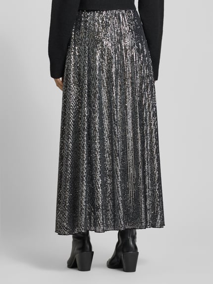 Frauenmodel trägt Maxirock mit Paillettenbesatz von Rich & Royal, Material-Mix mit Stretch-Anteil, lockerer Schnitt, Ganzkörperansicht Rückansicht.