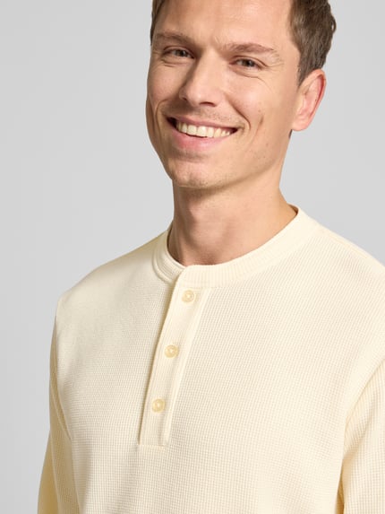 Männermodel trägt Regular Fit Pullover mit Knopfleiste Modell 'Kilano' von Drykorn, Baumwoll-Mix, Strukturmuster, Nahaufnahme Oberkörper.