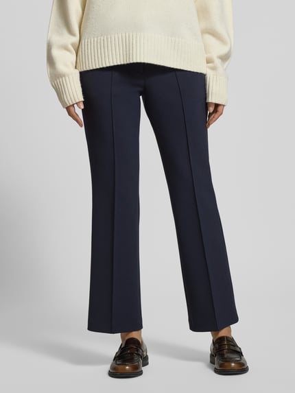 Vrouwenmodel draagt Flared Fit Stoffhose met Viskose-Anteil Modell 'Farah' van Cambio, donkerblauw, siernaad, frontale close-up.