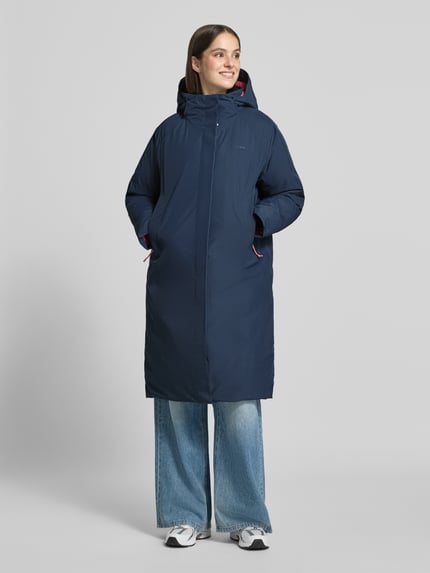 Frauenmodel trägt Parka mit echter Daune und 10.000 mm Wassersäule von Peak Performance, navy, Regular Fit, verdeckter Reißverschluss, Ganzkörperansicht von vorne.
