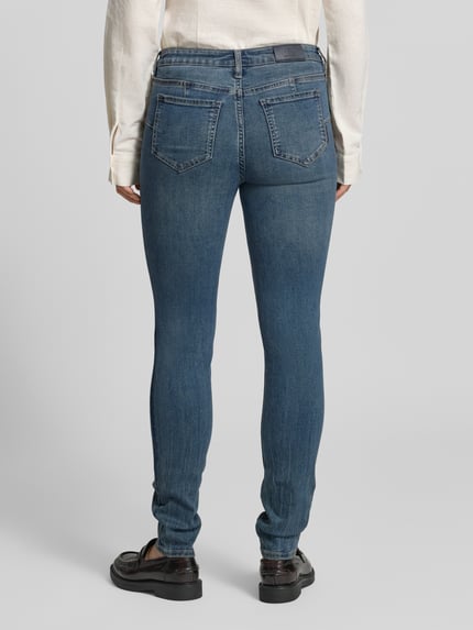 Frauenmodel trägt Skinny Fit Jeans mit Viskose-Anteil von Armani Exchange, blau, 5-Pocket-Design, Ganzkörperansicht Rückansicht.